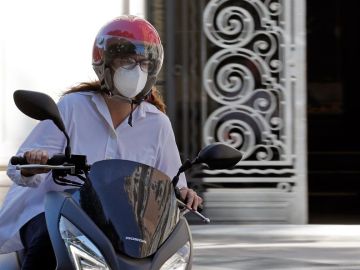Una motorista con mascarilla