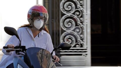 Una motorista con mascarilla en Valencia