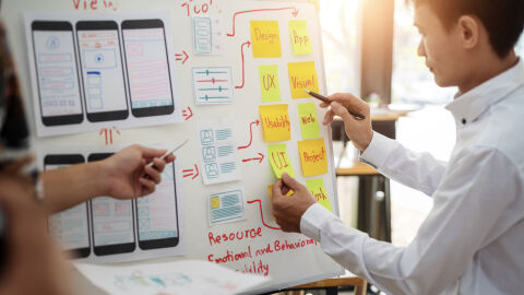 Diseñador web observa pizarra con la arquitectura de una página web Diseñador web observa pizarra con la arquitectura de una página web