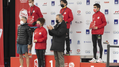 Los tres primeros clasificados de la categoría de 10KM en el podio junto a los entregadores