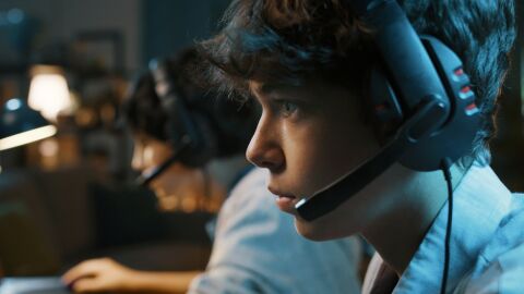 Jóvenes concentrados en la acción de un videojuego online.