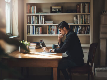 Un hombre muestra preocupaci&oacute;n mientras teletrabaja desde casa