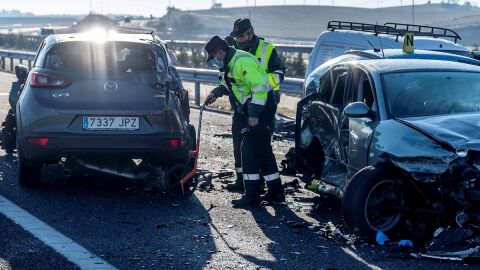 Agentes de la Guardia Civil revisan dos coches involucrados en un accidente de carretera