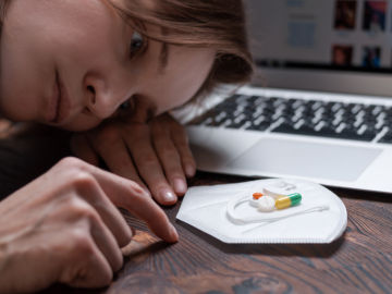 Una chica mira un pu&ntilde;ado de antidepresivos. Hay v&iacute;nculos entre trastornos mentales y las redes sociales