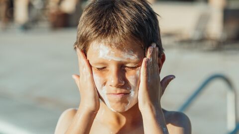 Cómo proteger correctamente la piel de los niños del sol en vacaciones Niño aplicándose crema solar en la cara