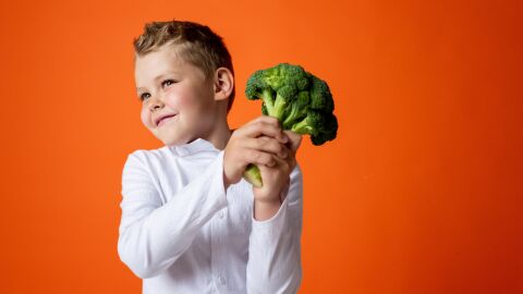 ¿Es perjudicial para los niños una dieta vegana? Niño pequeño sostiene un brócoli