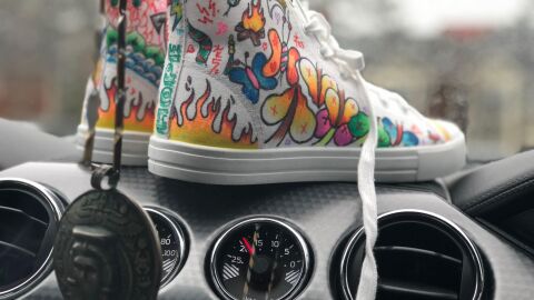 ¿Me pueden multar por conducir descalzo o en chanclas? Deportivas sobre el salpicadero del coche