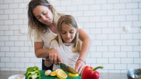 Los expertos recomiendan involucrar a los niños en tareas de compra y preparación de alimentos saludables Madre enseña a hija cocinar
