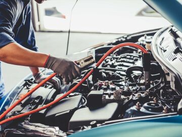 Imagen de un operario de taller revisando un coche.