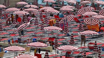 Bañistas buscan refugio del sol en una playa italiana en julio de 2023