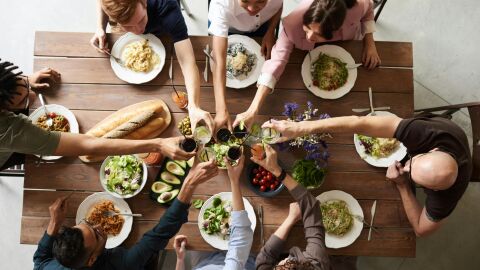 Un grupo de personas comiendo en la misma mesa 