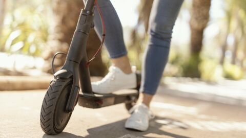 Mujer circulando en un patinete eléctrico Mujer circulando en un patinete eléctrico