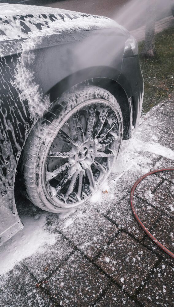 Coche con espuma con un chorro de agua