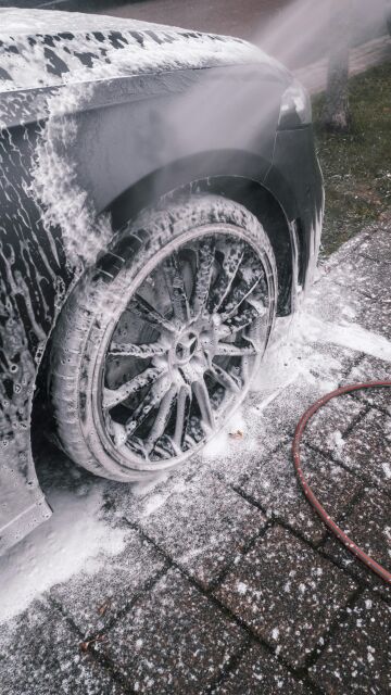 Lavado de coche Coche con espuma con un chorro de agua