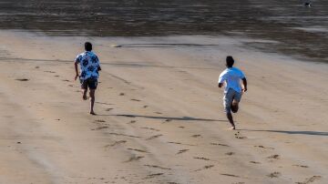 Dos personas corren en la playa