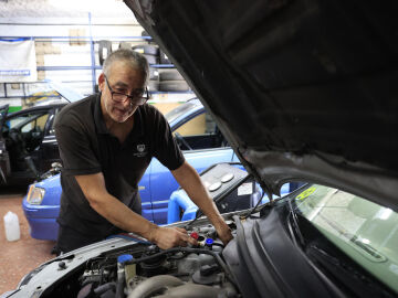 Un mec&aacute;nico revisa el estado de un veh&iacute;culo en un taller en Madrid.
