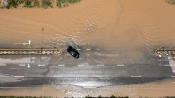 Coche en medio de carretera inundada por riada