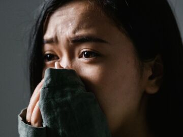 Primer plano de una mujer angustiada en interiores, mostrando ansiedad y estr&eacute;s