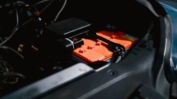 Vista detallada de la batería de un coche eléctrico dentro del compartimento del motor del vehículo, destacando la tecnología sostenible.