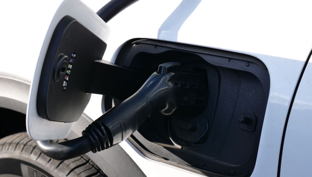 Vista en primer plano de un vehículo eléctrico cargándose, con especial atención al conector y al puerto de carga Vista en primer plano de un vehículo eléctrico cargándose, con especial atención al conector y al puerto de carga