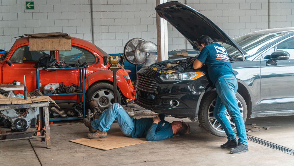 Mecánicos trabajando en un taller de automóviles Mecánicos trabajando en un taller de automóviles