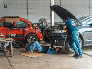Mec&aacute;nicos trabajando en un taller de autom&oacute;viles
